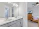 Double vanity bathroom with gray cabinets and view into bedroom at 1861 Goblet Cove St, Kissimmee, FL 34746