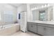 Elegant bathroom with soaking tub, double vanity, and linen storage at 1861 Goblet Cove St, Kissimmee, FL 34746