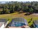 Aerial view of a screened-in pool and spa with lush green surroundings at 1861 Goblet Cove St, Kissimmee, FL 34746