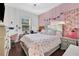 Bedroom with floral bedding and pink walls at 1954 Filly Trl, Oviedo, FL 32765