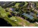 Aerial view of golf course, tennis courts, and clubhouse near a lake at 237 Hazeltine Dr, Debary, FL 32713