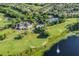 Aerial view of golf course, clubhouse, pool, and tennis courts at 237 Hazeltine Dr, Debary, FL 32713