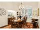 Formal dining room featuring a wooden table, chandelier, and plantation shutters at 237 Hazeltine Dr, Debary, FL 32713