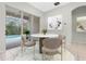 Bright dining area with a round marble table, modern chairs, and sliding door access to the pool at 2555 Sand Arbor Cir, Orlando, FL 32824