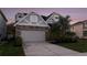 Attractive two-story home boasting stone details, manicured landscaping, and a two-car garage at 2555 Sand Arbor Cir, Orlando, FL 32824