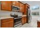 Modern kitchen featuring stainless steel appliances, wooden cabinets, and tile flooring at 2555 Sand Arbor Cir, Orlando, FL 32824