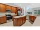 Spacious kitchen featuring stainless steel appliances, a central island, and wood cabinetry at 2555 Sand Arbor Cir, Orlando, FL 32824