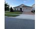 Gray house with a two-car garage, brick driveway, and neatly landscaped front yard at 3333 Wauseon Dr, Saint Cloud, FL 34772