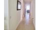 Bright hallway with tile floors, leading to a living area with a gray couch at 3333 Wauseon Dr, Saint Cloud, FL 34772