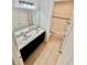 Bright bathroom featuring double sinks, a black cabinet, neutral tile flooring and a tub with white tiling at 3333 Wauseon Dr, St Cloud, FL 34772