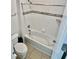 White bathtub and toilet featuring neutral accent tile and neutral floor tile at 3333 Wauseon Dr, St Cloud, FL 34772