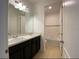 Bright bathroom featuring double sinks, a black cabinet, neutral tile flooring and a tub with white tiling at 3333 Wauseon Dr, St Cloud, FL 34772