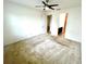 A bedroom with a ceiling fan and an open doorway leading to a bathroom at 3333 Wauseon Dr, St Cloud, FL 34772
