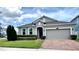 Lovely home featuring a well-maintained lawn, brick driveway, and attached two-car garage at 3333 Wauseon Dr, St Cloud, FL 34772