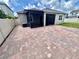 Rear exterior view featuring brick pavers, screened in patio, and a trimmed lawn at 3333 Wauseon Dr, St Cloud, FL 34772