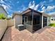 Back exterior featuring brick paver patio, screened in porch, and air conditioning unit at 3333 Wauseon Dr, St Cloud, FL 34772