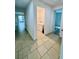 Hallway leading to laundry room and other areas of home featuring neutral tile flooring at 3333 Wauseon Dr, St Cloud, FL 34772