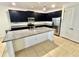Close-up view of a modern kitchen island with dark cabinets, granite countertops and stainless appliances at 3333 Wauseon Dr, St Cloud, FL 34772