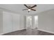 Bedroom with double doors to bathroom and grey wood-look floors at 3650 Se 140Th Pl, Summerfield, FL 34491