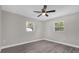 Spacious bedroom with two windows, ceiling fan and hardwood floors at 3650 Se 140Th Pl, Summerfield, FL 34491