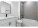 Modern bathroom with grey tile, white vanity, and bathtub at 4774 Sw 152Nd Ln, Ocala, FL 34473