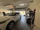 Garage with white SUV, storage shelving, and workbench at 551 Lake Charles Dr, Davenport, FL 33837