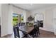 Dining room with a dark wooden table and six chairs, looking out to the backyard at 5808 Galloping Dr, Apopka, FL 32712