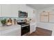 Modern kitchen with white cabinets, stainless steel appliances, and a quartz countertop at 5808 Galloping Dr, Apopka, FL 32712