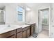 Modern bathroom with double vanity, wood cabinets, and window at 671 Bloom Ter, Davenport, FL 33837