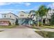 Two-story house with gray siding, teal garage door, and landscaped yard at 671 Bloom Ter, Davenport, FL 33837