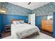 Mid-century modern bedroom with blue walls and a patterned wallpaper accent at 7202 Chelsea Harbour Dr, Orlando, FL 32829