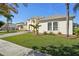 Two story house with a light yellow exterior, palm trees, and manicured lawn at 7202 Chelsea Harbour Dr, Orlando, FL 32829