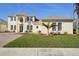 Two-story house with a light-yellow exterior, paved driveway, and manicured lawn at 7202 Chelsea Harbour Dr, Orlando, FL 32829