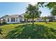 Two-story house with a large backyard, mature trees, and a covered patio at 7202 Chelsea Harbour Dr, Orlando, FL 32829