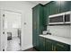 Well-equipped kitchen with dark green cabinetry, white countertops, and built-in microwave at 7202 Chelsea Harbour Dr, Orlando, FL 32829