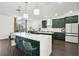 Modern kitchen with dark green cabinets, white countertops, and an island at 7202 Chelsea Harbour Dr, Orlando, FL 32829