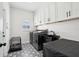 Bright laundry room with washer, dryer, utility sink, and black and white patterned floor at 7202 Chelsea Harbour Dr, Orlando, FL 32829