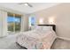 Cozy bedroom with a queen bed and sliding door access to balcony at 7697 Fairfax Dr, Kissimmee, FL 34747