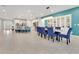 Open dining room with blue chairs and white cabinets at 7697 Fairfax Dr, Kissimmee, FL 34747