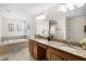 Bathroom with double vanity, granite countertop, and a soaking tub at 8882 Candy Palm Rd, Kissimmee, FL 34747