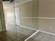 Living room with tile floors, mirrored wall, and door to hallway at 950 Lake Destiny Rd # E, Altamonte Springs, FL 32714