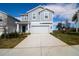 Two-story house with gray siding, two-car garage, and landscaping at 1053 Waterfall Blvd, Davenport, FL 33837