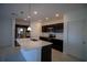 Modern kitchen with dark cabinets, stainless steel appliances, and an island at 1053 Waterfall Blvd, Davenport, FL 33837