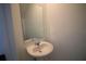 Small powder room with pedestal sink and mirror at 1053 Waterfall Blvd, Davenport, FL 33837