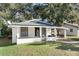 White bungalow home with a green metal roof and carport at 122 Magnolia Dr, Winter Haven, FL 33881