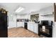 White kitchen with stainless steel appliances and wood flooring at 122 Magnolia Dr, Winter Haven, FL 33881