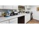 White kitchen with quartz countertops and stainless steel appliances at 122 Magnolia Dr, Winter Haven, FL 33881