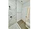 Bathroom with marble shower and wood-look floors at 1304 Hillsborough Ct, Kissimmee, FL 34759