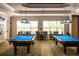 Game room with two billiard tables, comfortable seating, and large windows at 1351 Venezia Ct # 304, Davenport, FL 33896