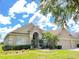 Tan one-story house with palm trees and manicured lawn at 142 Winghurst Blvd, Orlando, FL 32828